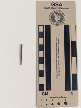 Corroded nail with a small rectangular shaft.