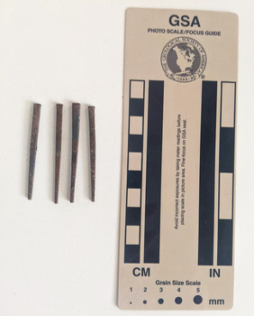 Collection of four corroded nails square in shape that narrows to a blunt tip.