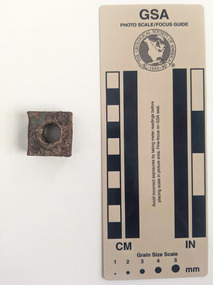Square shaped nut with circular perforation.