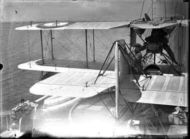 Photograph, Bull, Hugh Jones, 1897-1993, Australian Navy Supermarine Seagull III bi-plane on a ship with mechanic (left side)