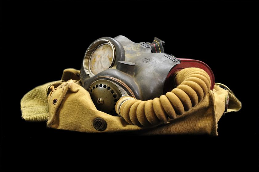 a gas mask and goggles with breathing apparatus against black