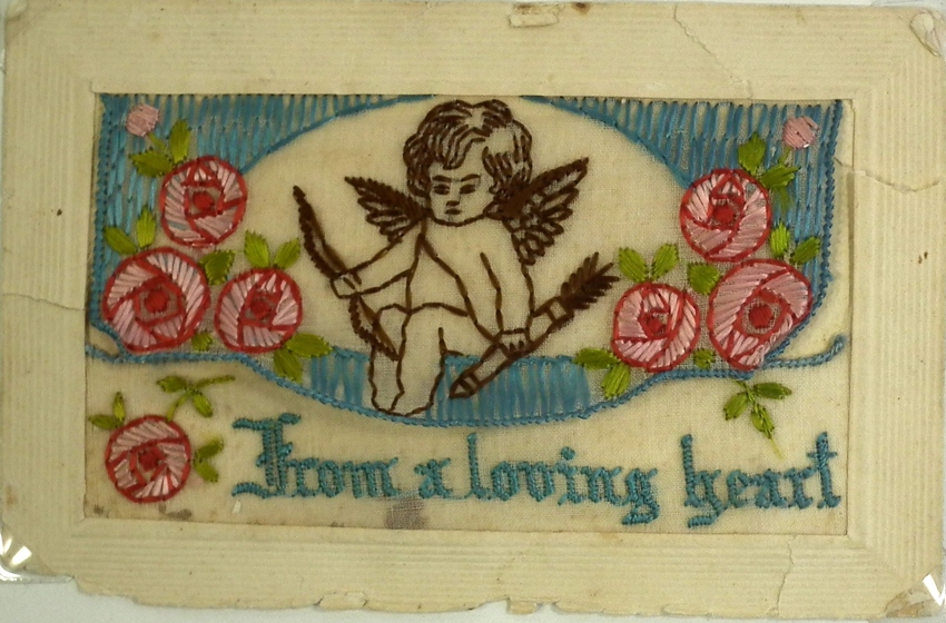 an embroidered cherub with roses on card