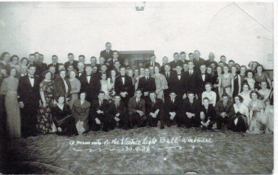 crowd of men and women posing for photograph