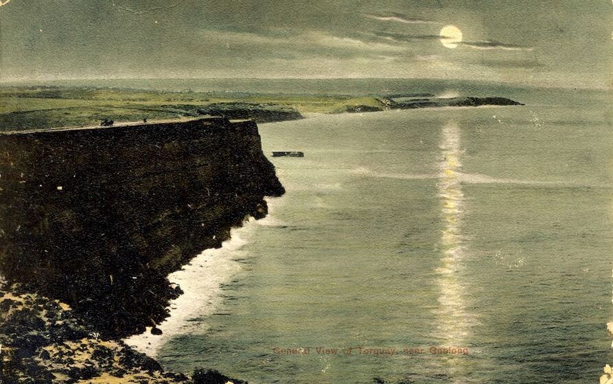 cliffs near ocean's edge with moon above