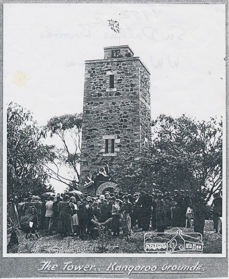 crowd gathered under stone tower memorial