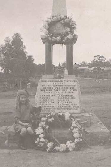 young girl and dog with wreath at memorial
