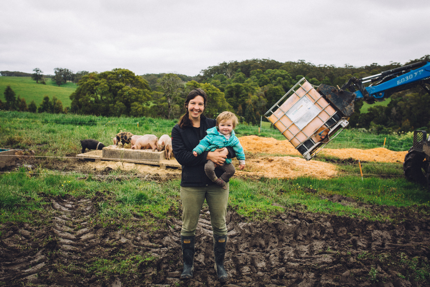 Woman holding baby near a machine