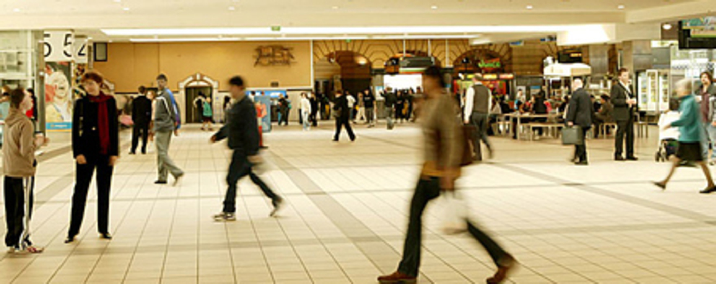 a blurry image of people passing swiftly through the concourse
