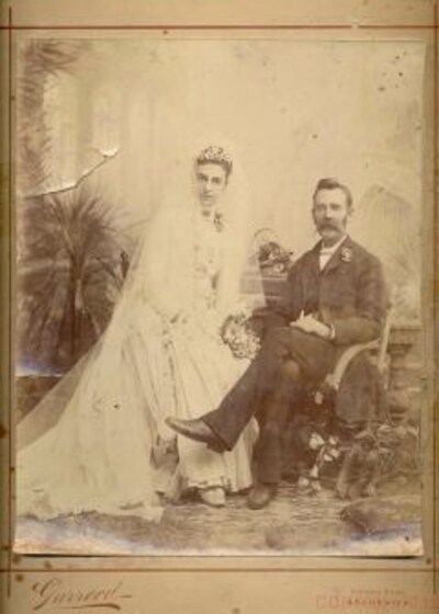 a bride and groom sitting next to each other for wedding photo