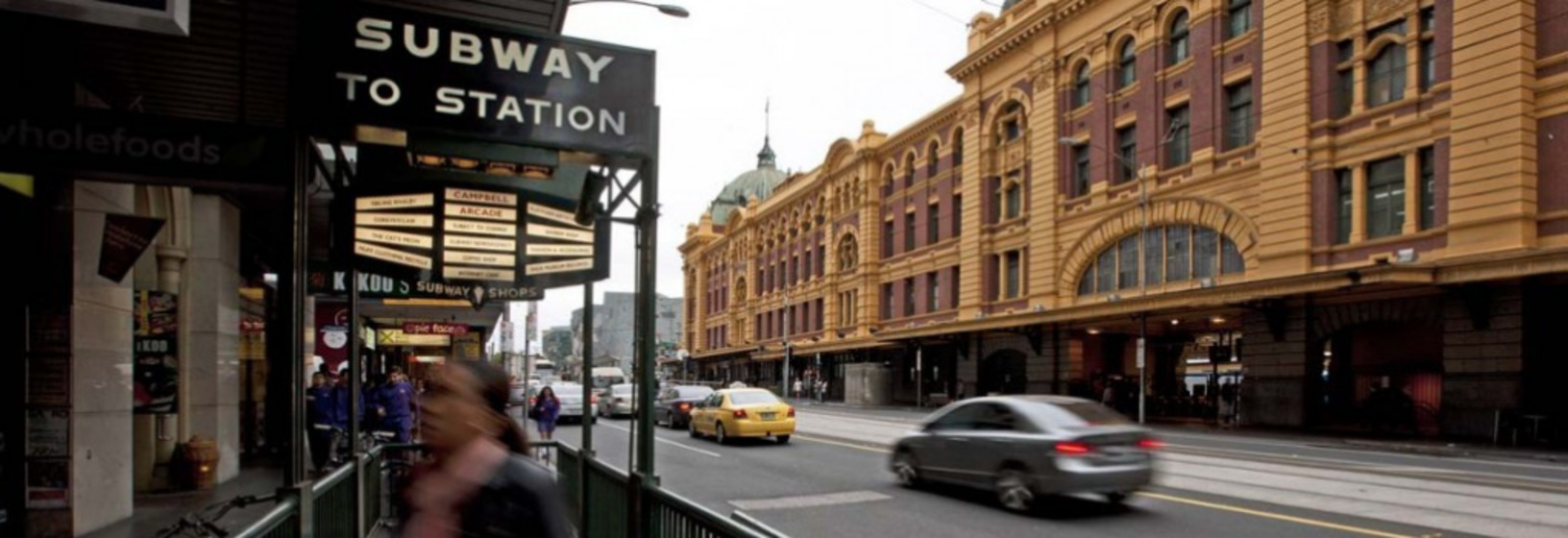 looking down Flinders Street with the station building opposite and the subway entrance ahead