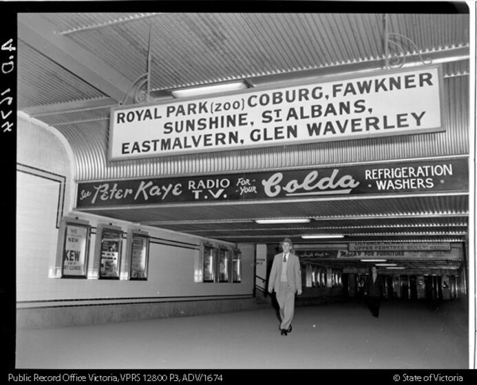 a man walking out of a subway entrance with signs above head