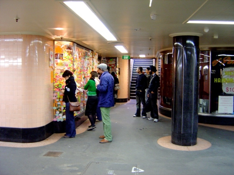 people gather to explore a recent exhibition in the arcade