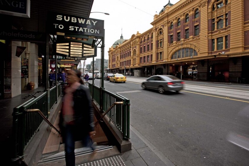 looking down Flinders Street with the stationbuilding opposite and the subway entrance ahead