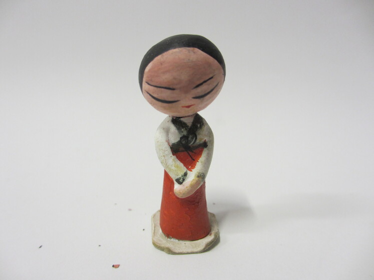 hand-made modelled doll with a painted white and red dress