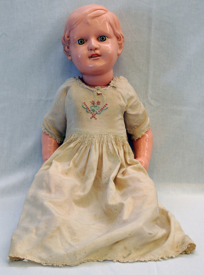 Doll in cream dress with embroidered motif