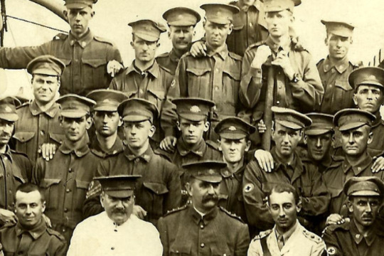 a group of men in assorted military uniform onboard a ship
