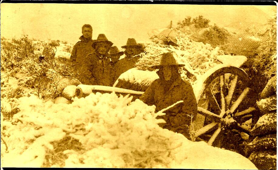 six uniformed men witha military gun on a wagon