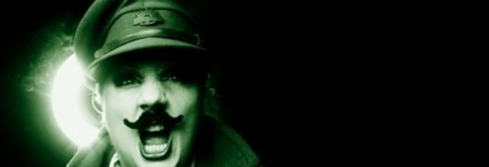 head of man with mustache wearing a hat, light shining from behind