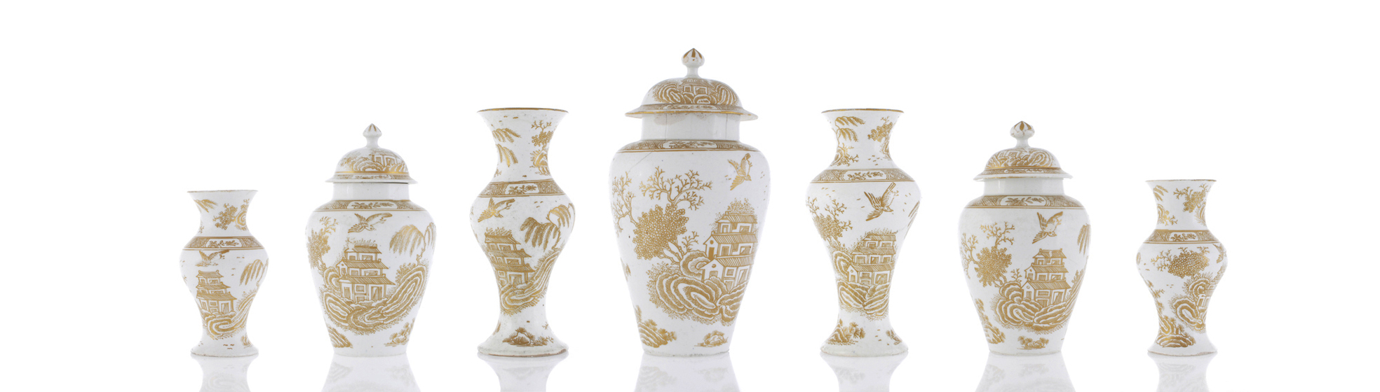 seven white porcelain lidded vases with gold gilt decoration. 