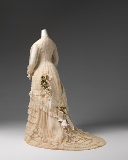 a wedding dress with train on mannequin, seen from back