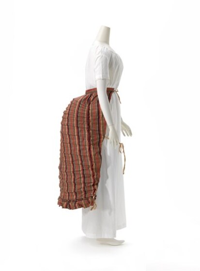 Red-toned bustle displayed on a mannequin 