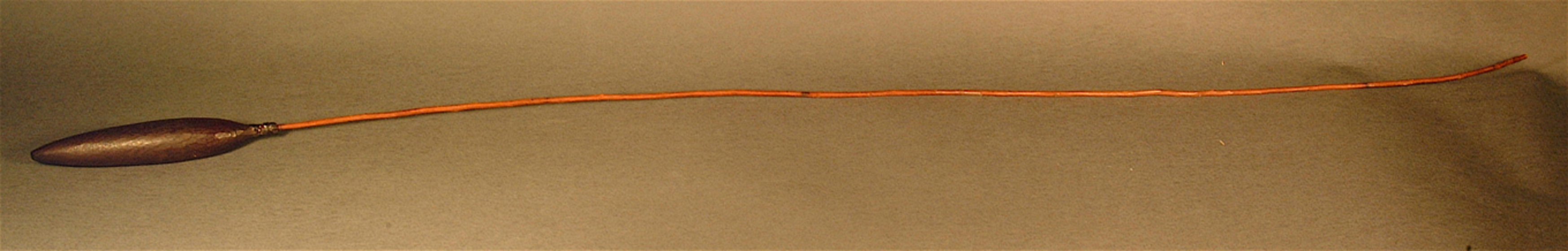 a long thin bird hunting stick pictured on a grey background