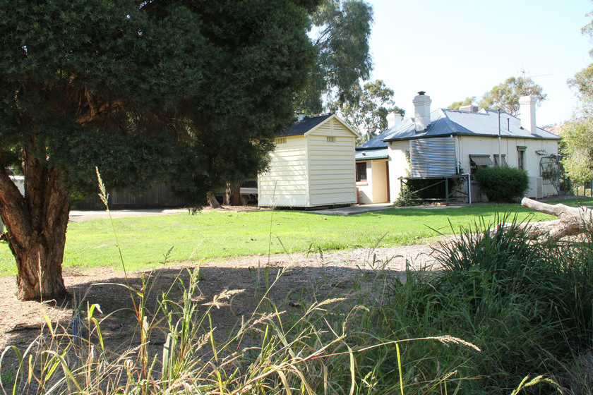 Location of Ned Kelly’s Capture Site, country suburban block with a large tree, lawn in the foreground and house in the background.