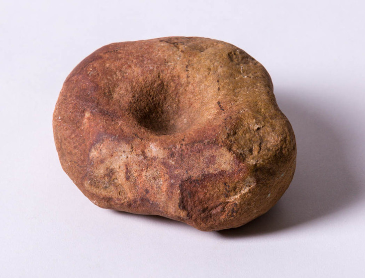 large, round stone with small central hollow