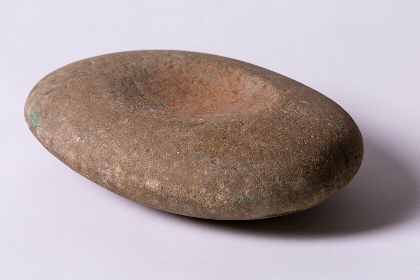 large oval-shaped stone with worn hollow in centre