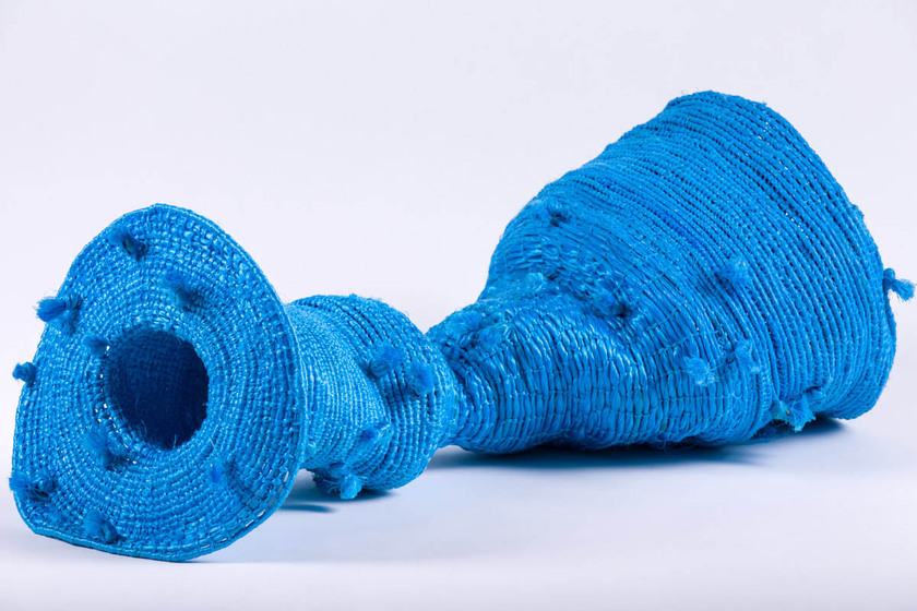 bright blue twine has been woven into a long, circular trap with a wide flat mouth at opening and funnel shape at rear