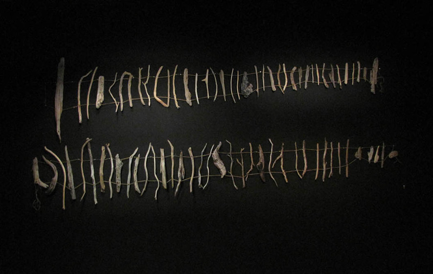two groups of assorted driftwood sticks, suspended on four string lines 