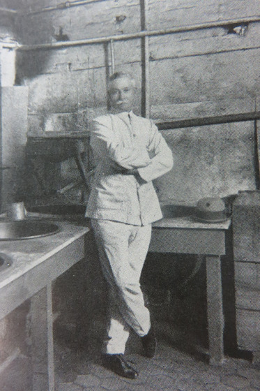 Man leaning up against table with arms crossed
