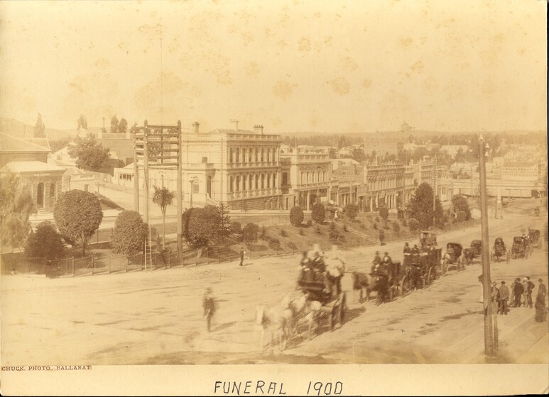 Sepia photograph of carriage procession down street