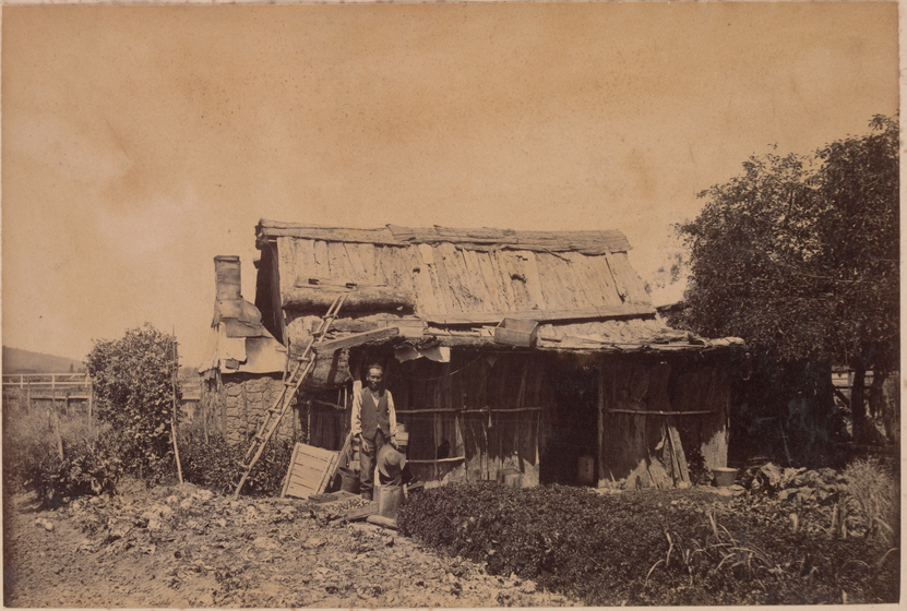 Chinese man outside wooden hut