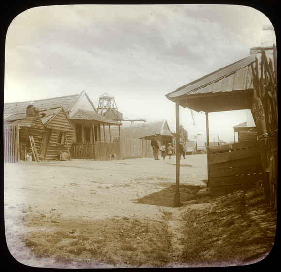 Several wooden buildings lining a rough road