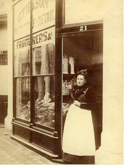 Woman in dress standing outside of shop door