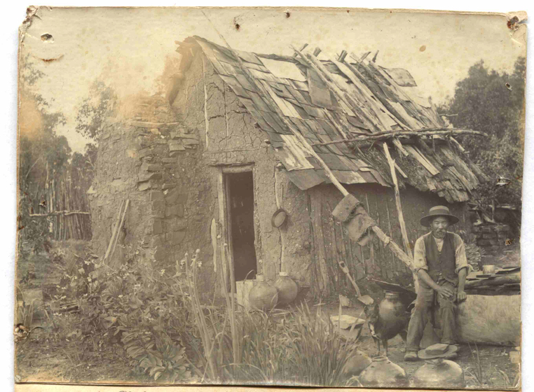 Man standing outside of wooden shack