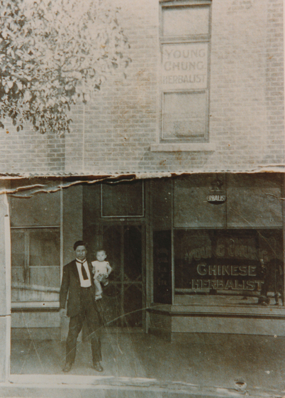 Man and child standing outside of shop