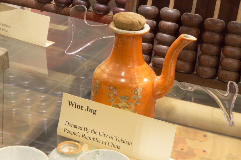 Yellow wine jug sitting on a glass shelf