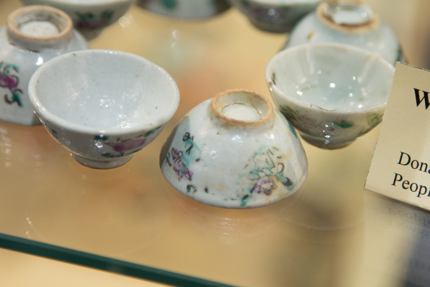 Several wine cups atop a glass shelf