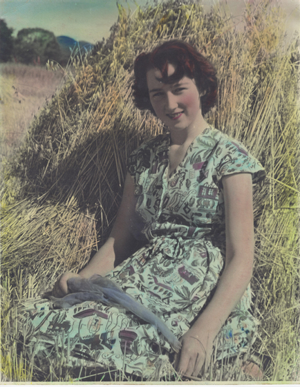 Young woman sitting atop a hay pile