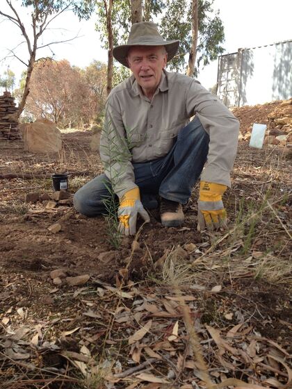 Man kneeling down to the ground wearing gloves