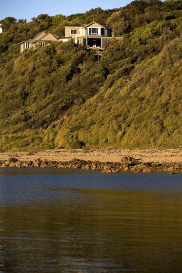 House on top of a hill by a body of water