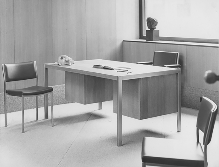 Interior of an office, desk and three chairs