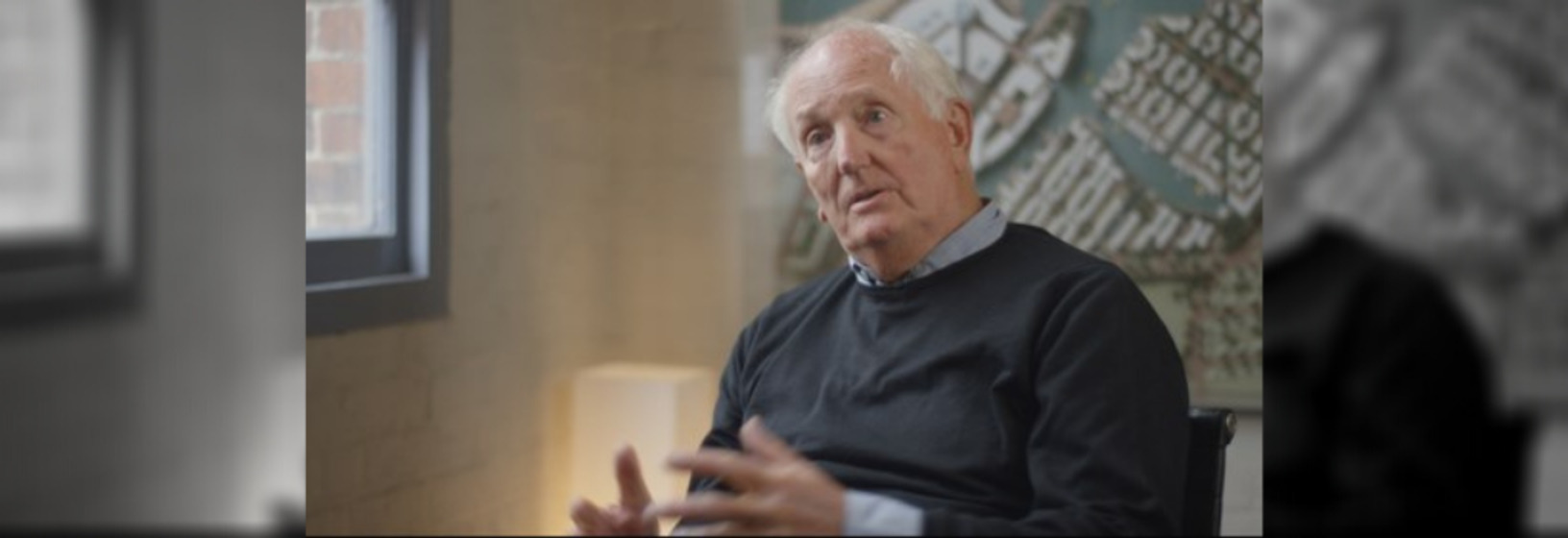 Man sitting on chair, talking to the camera