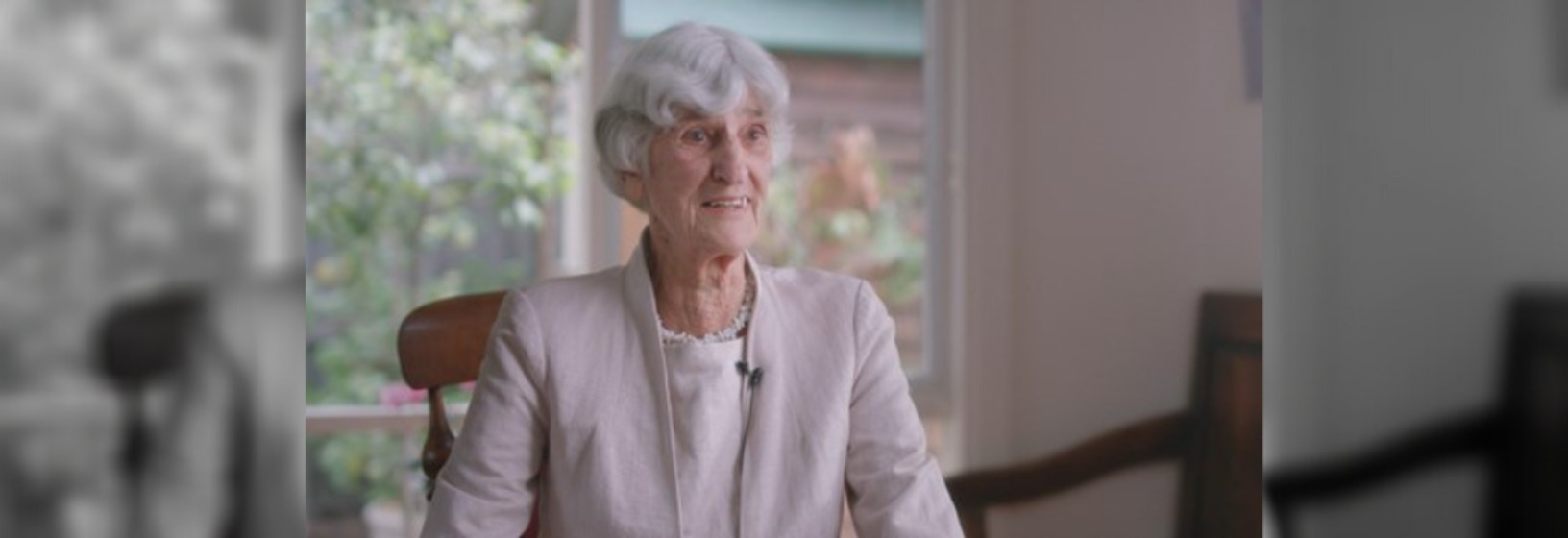 Woman sitting, addressing the camera