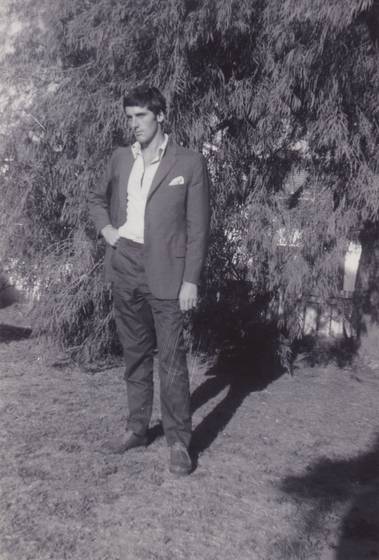 Suited man standing in a garden