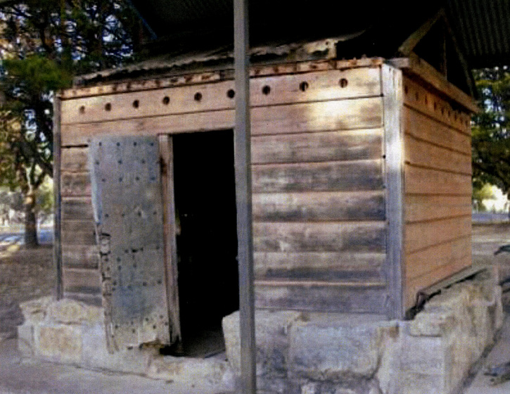Old wooden lock-up building with open door
