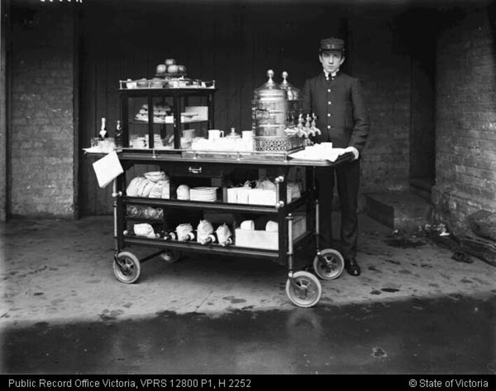 Man standing next to a full serving trolley
