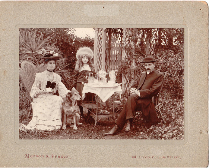People sitting in chairs in a garden, sepia toned